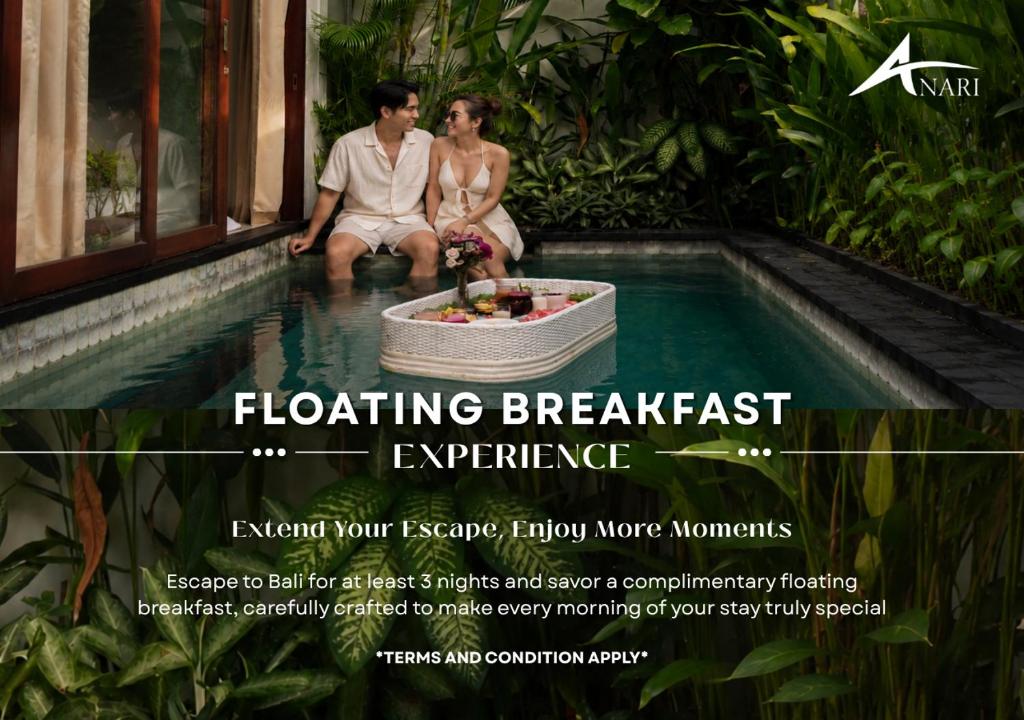 a man and a woman sitting next to a swimming pool at Anari Villas Kuta by The Wina Resorts in Legian