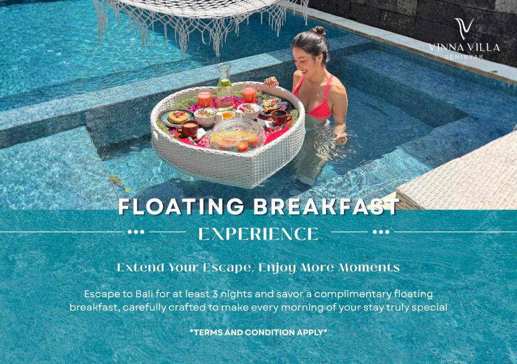 a woman in a swimming pool with a basket of fruit at Vinna Villa Seminyak by The Wina Resorts in Kerobokan