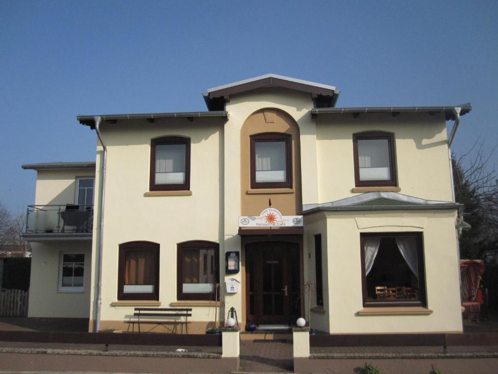 een groot geel huis met een dak bij Pension Villa Wolkenlos in Dahme