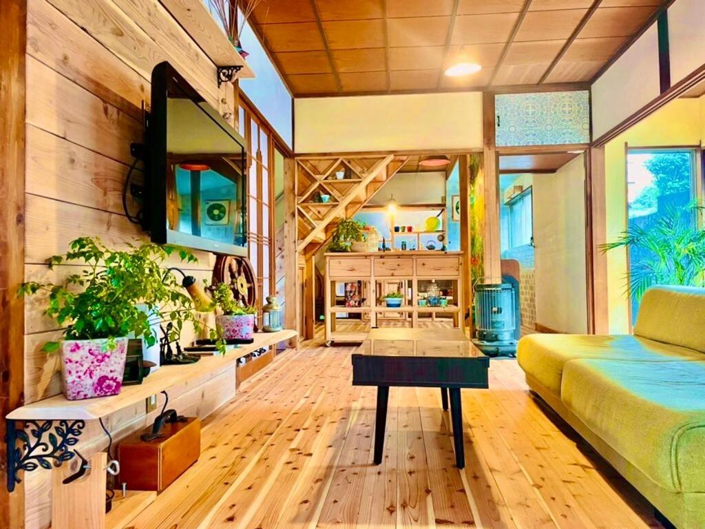 a living room with a couch and a tv at The Sticks Inatori in Higashiizu