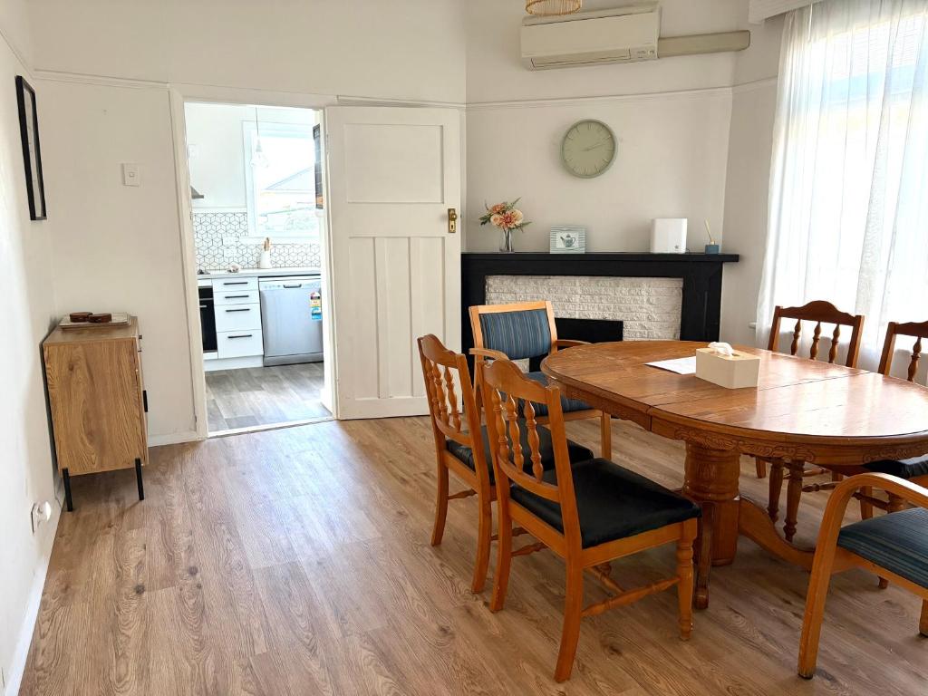 a kitchen and dining room with a wooden table and chairs at Pretty Villa Close to St Clair Beach private parking in Dunedin