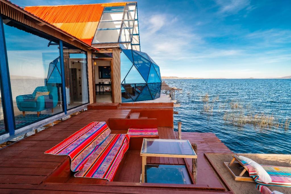 a boat deck with a table and benches on the water at Uros Titicaca Kurmi lodge in Puno