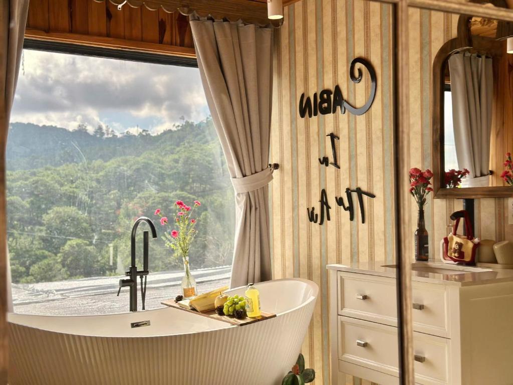 a bathroom with a tub and a window with a view at Cabin In The Air in Ấp Ða Lợi
