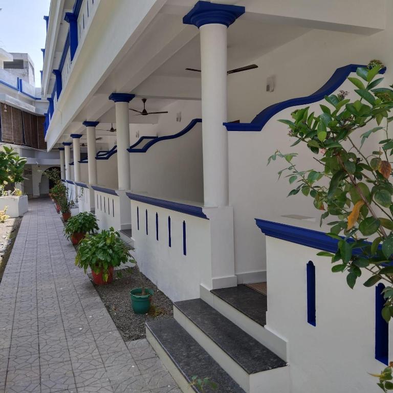 a corridor of a building with blue and white columns at Hotel Neptune Kovalam in Trivandrum