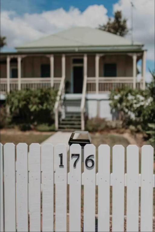 a white picket fence in front of a house at Oakmore Cottage Charming Old Vintage Queenslander - Central location in Bundaberg