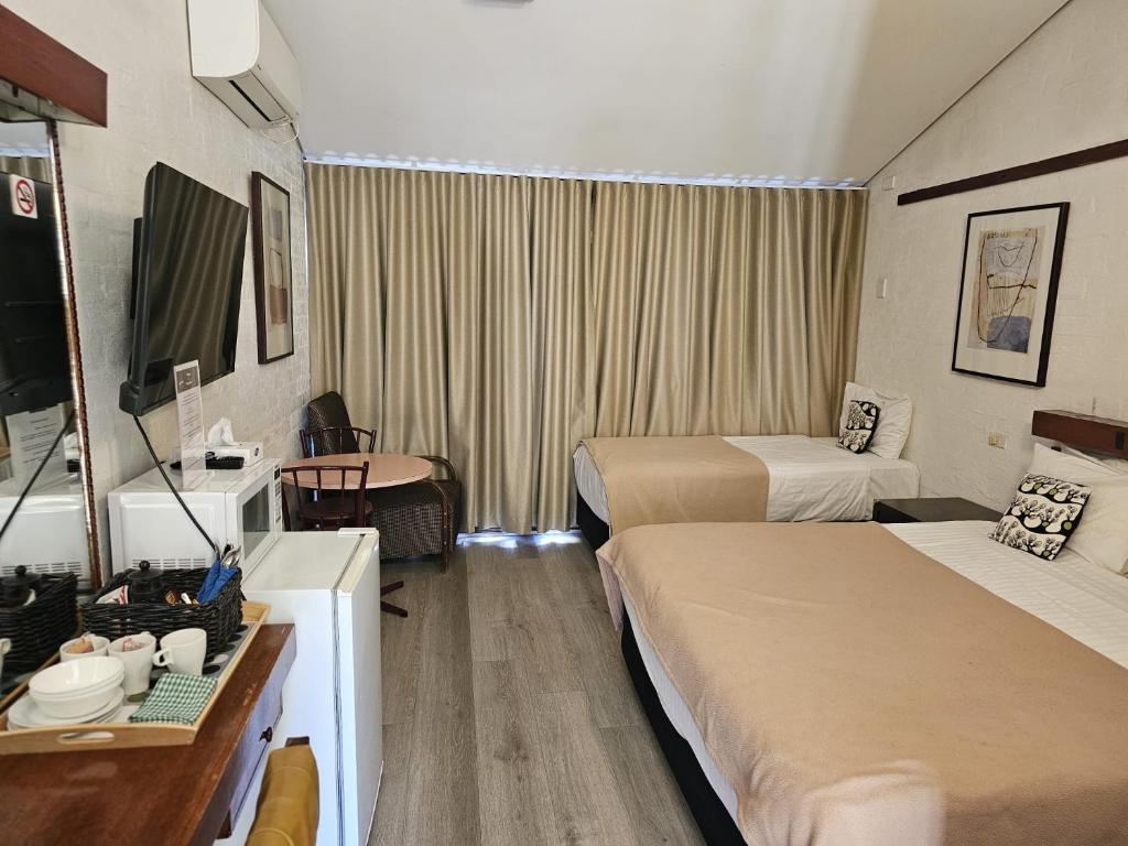 a hotel room with two beds and a television at The Apple Inn in Batlow