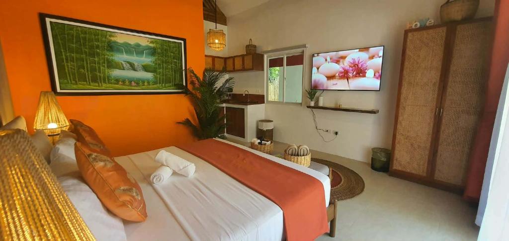 a bedroom with a bed with an orange wall at lala-Oh Resort in Lalao