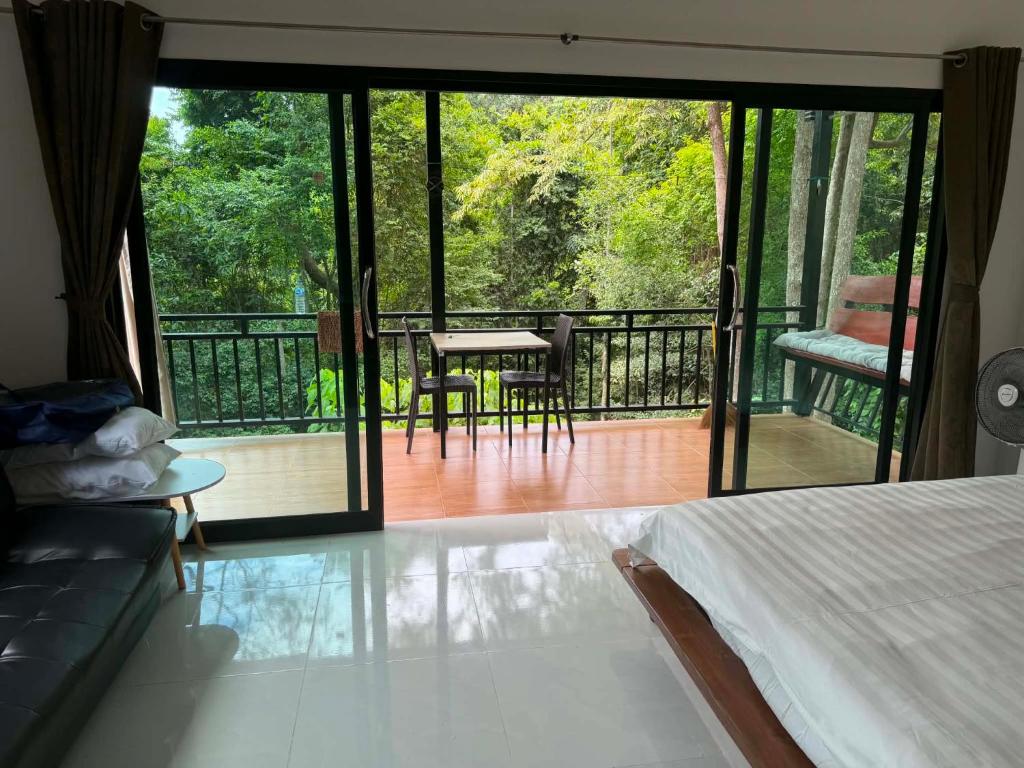 a room with a bed and a balcony with a table and chairs at Khao Raa Terrace 6 in Ko Phangan