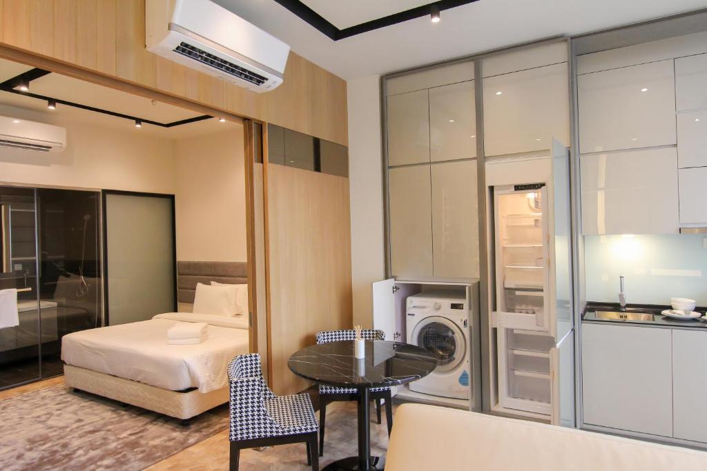 a bedroom with a bed and a table and a washing machine at WGS Suites at KLCC, 300Mbps WiFi in Kuala Lumpur