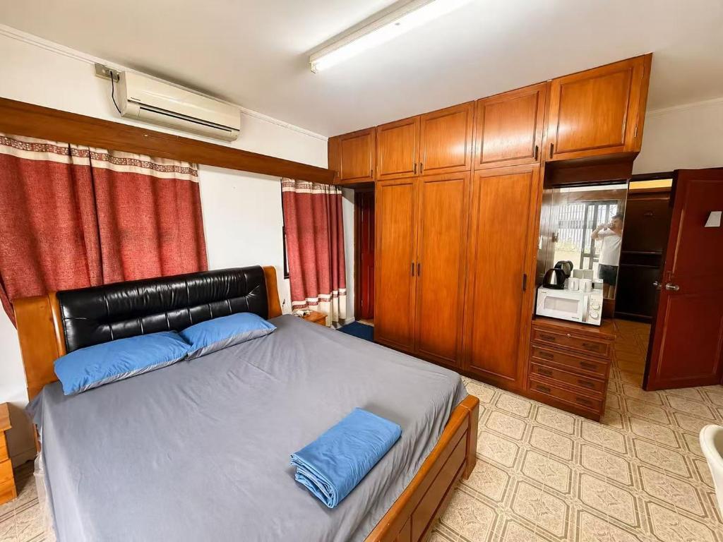 a bedroom with a bed and wooden cabinets at King Room with Private Bathroom and Free WiFI in SUVA CBD in The Domain