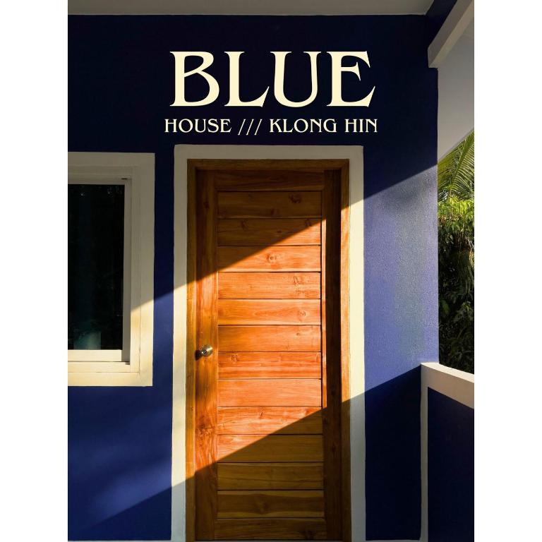 a blue house with a wooden door in front at Blue House Klong Hin in Ko Kood