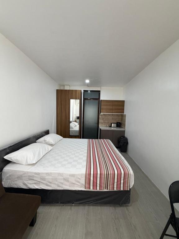 a bedroom with a large bed and a kitchen at Malima Stay in Suva