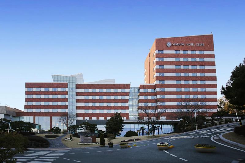 a large office building with a parking lot in front of it at Geoje Samsung Hotel in Geoje