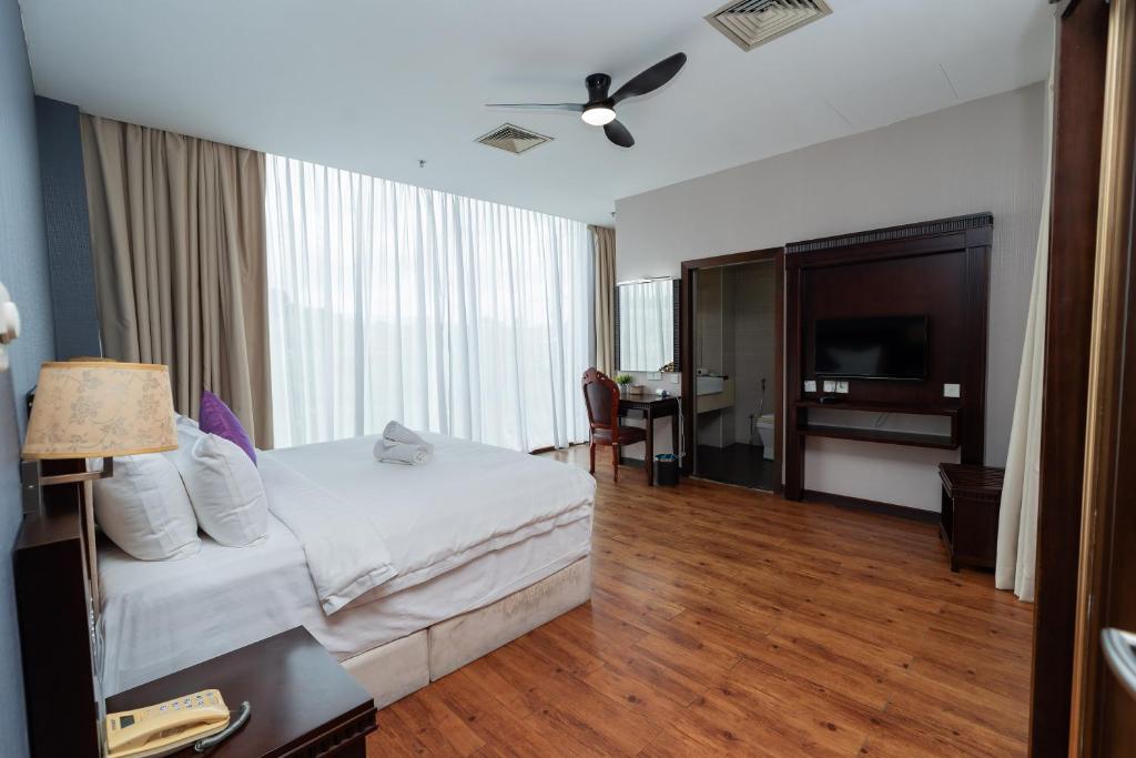 a bedroom with a bed and a desk and a television at Kingston Hotel 18 - Kuala Lumpur Sri Damansara in Kuala Lumpur