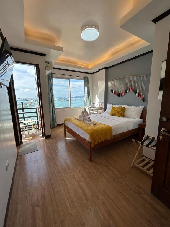a bedroom with a bed and a large window at Morocco Hotel El Nido in El Nido