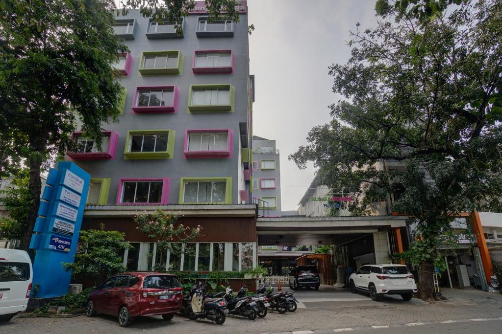 a tall building with motorcycles parked in front of it at Hotel Bunga-Bunga By ARBA in Jakarta