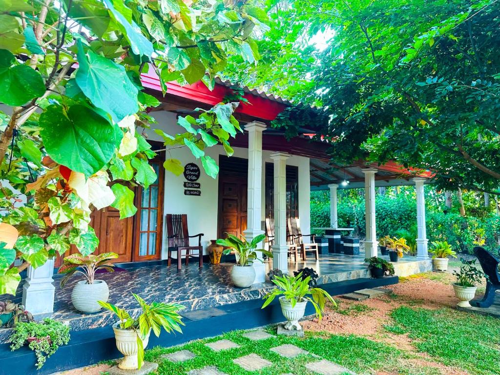 a house with a porch with potted plants on it at Sigiri Grand Villa in Sigiriya