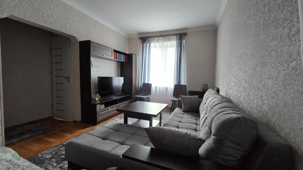 a living room with a couch and a television at Avenue B&B in Vanadzor