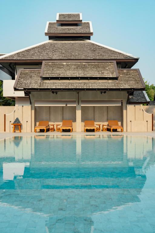 a building with a pool of water in front of it at Rimping Village in Chiang Mai