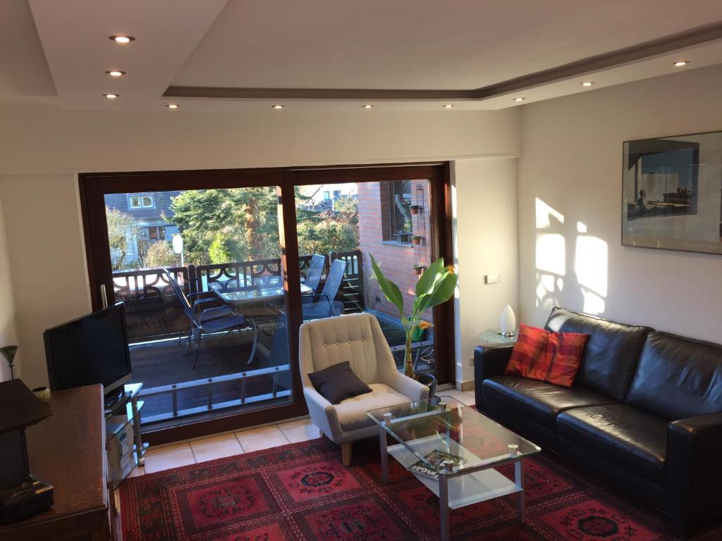 a living room with a couch and a balcony at Haus 23 in Korschenbroich