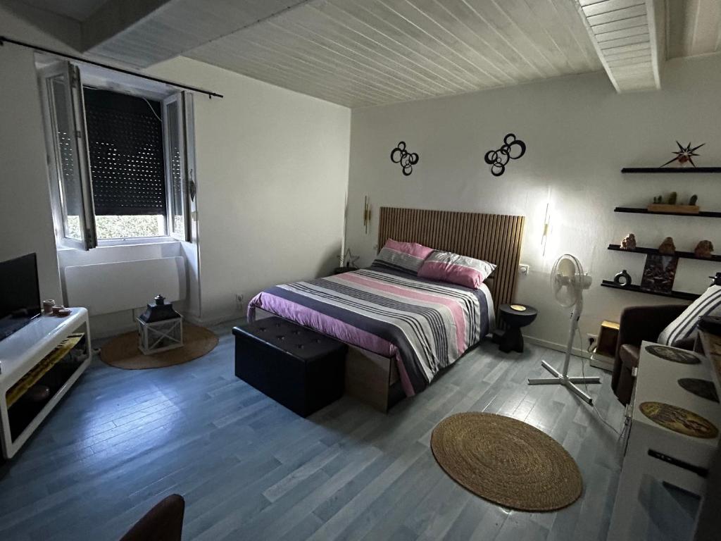 a bedroom with a bed and a couch in it at Sevchris in Saint-Laurent-de-la-Prée