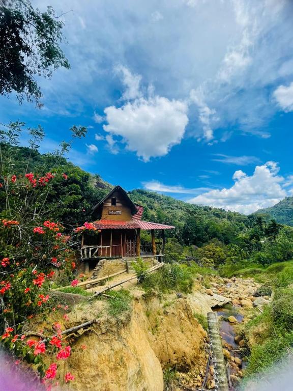 a small building on the side of a hill with flowers at Clay house in Kurukohogama