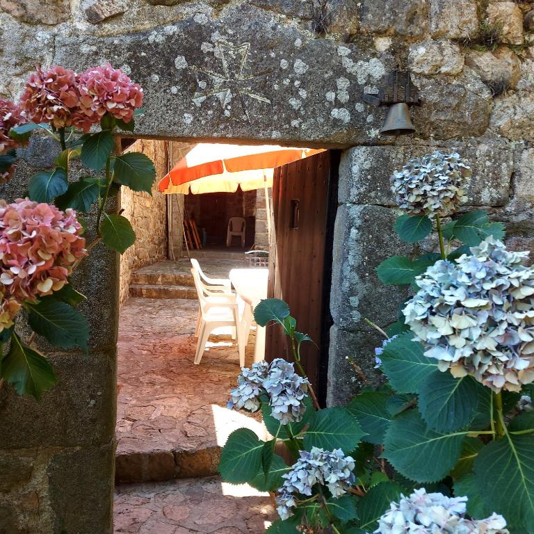 an entrance to a building with flowers in the doorway at Charensol in Saint-Sauveur-de-Montagut