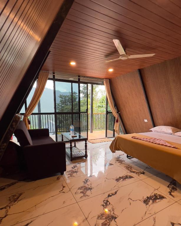 a bedroom with a bed and a ceiling fan at Tribez Valley Resort in Anaviratty