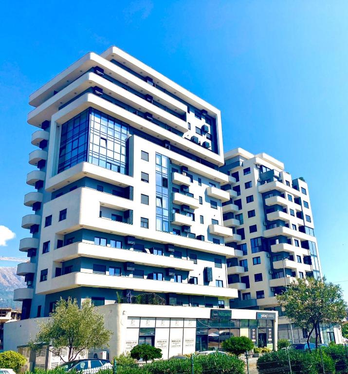 a tall white apartment building with blue windows at Doce Refugio in Bar