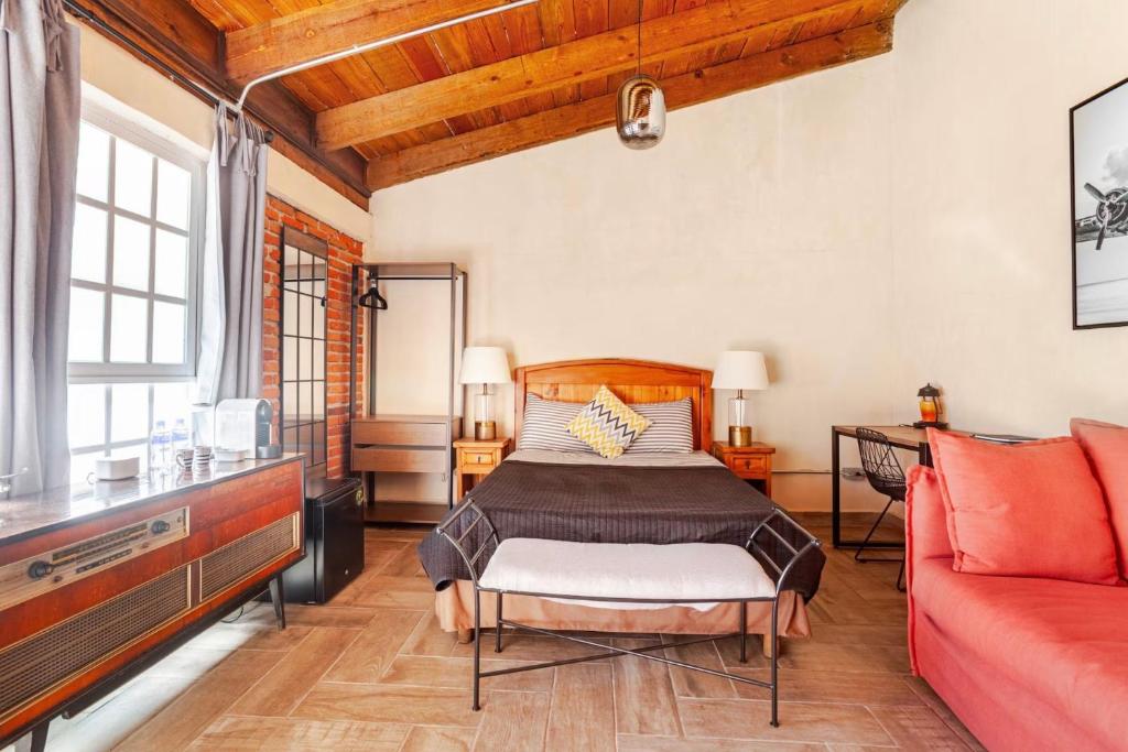 a bedroom with a bed and a red couch at Onenki in Hacienda Ojo de Agua