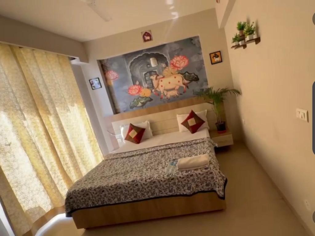 a bedroom with a bed and a painting on the wall at Blue Mans Rooms - Near Prem Mandir & ISKCON in Vrindāvan