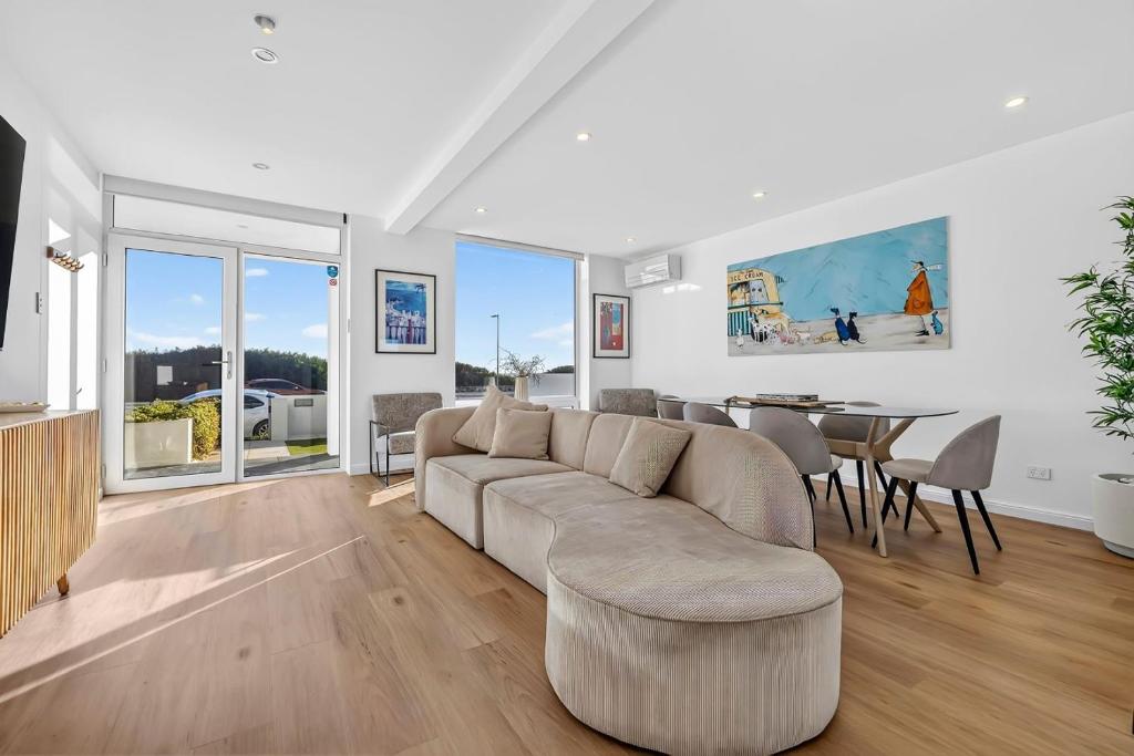 a living room with a couch and a table at Sunset Sands on Esplanade By Host Solutions in West Beach