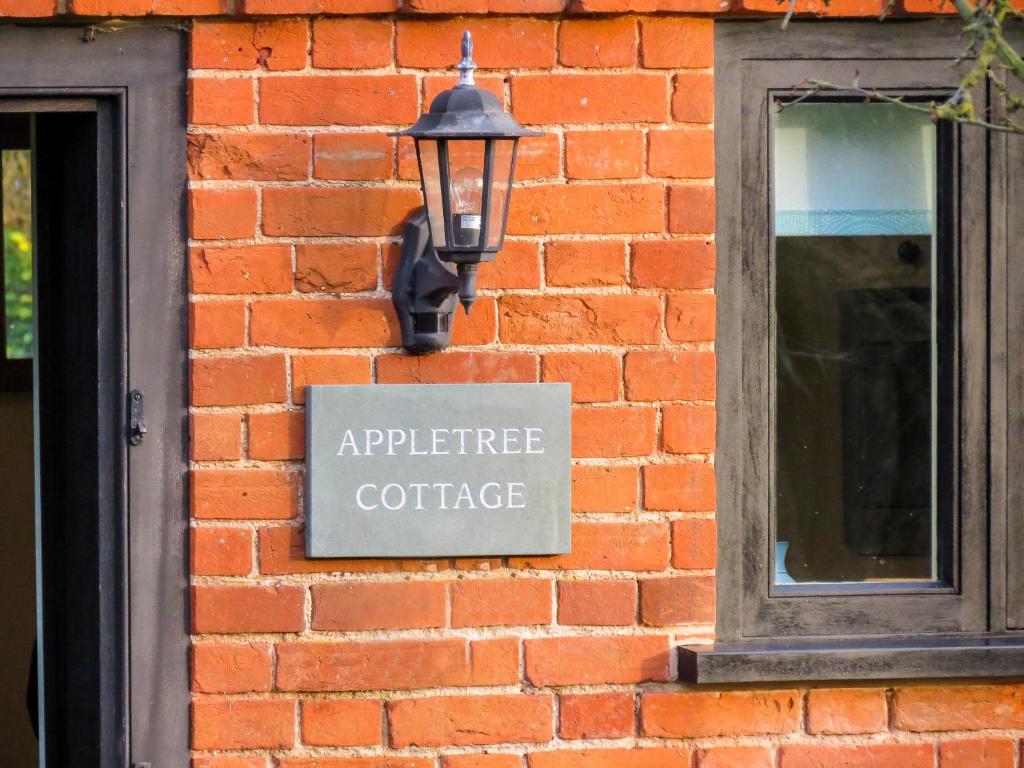 Fressingfield的住宿－Appletree Cottage Fressingfield，砖墙边的标志
