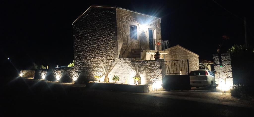 a building with lights on the side of it at night at La casa di Jacopo in Modica