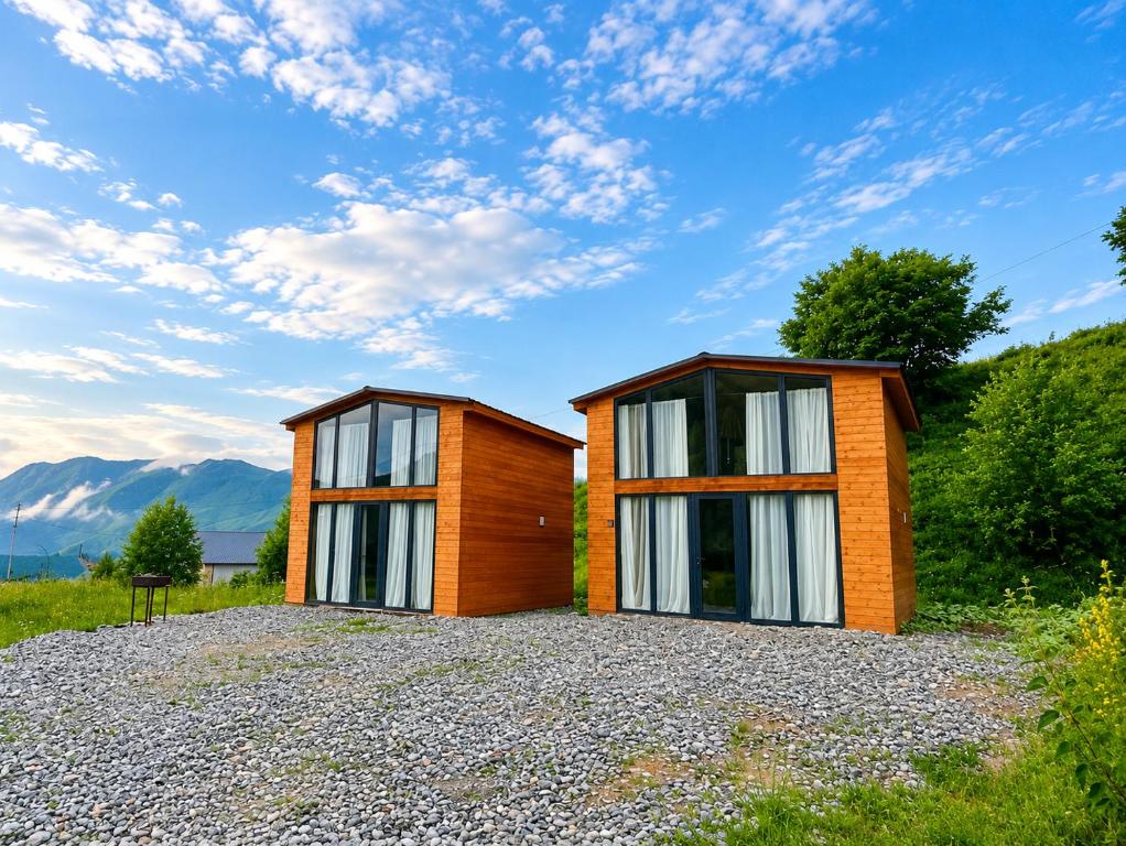 a house with two windows on a gravel lot at Gudauri Deka Alpine Cottages in Gudauri