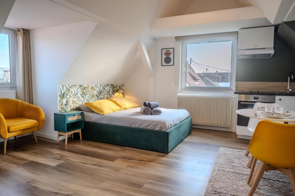 a small bedroom with a bed and a kitchen at Les Cognassiers - Studio Cosy & Equipé - Parking Gratuit - Professionnels & Familles in Illkirch-Graffenstaden