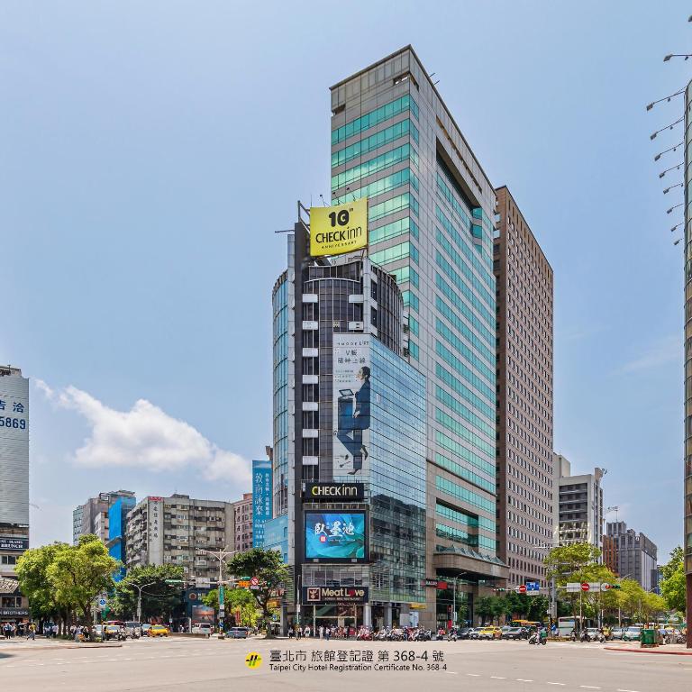 a tall building with a sign on it in a city at CHECK inn Taipei Xinyi in Taipei