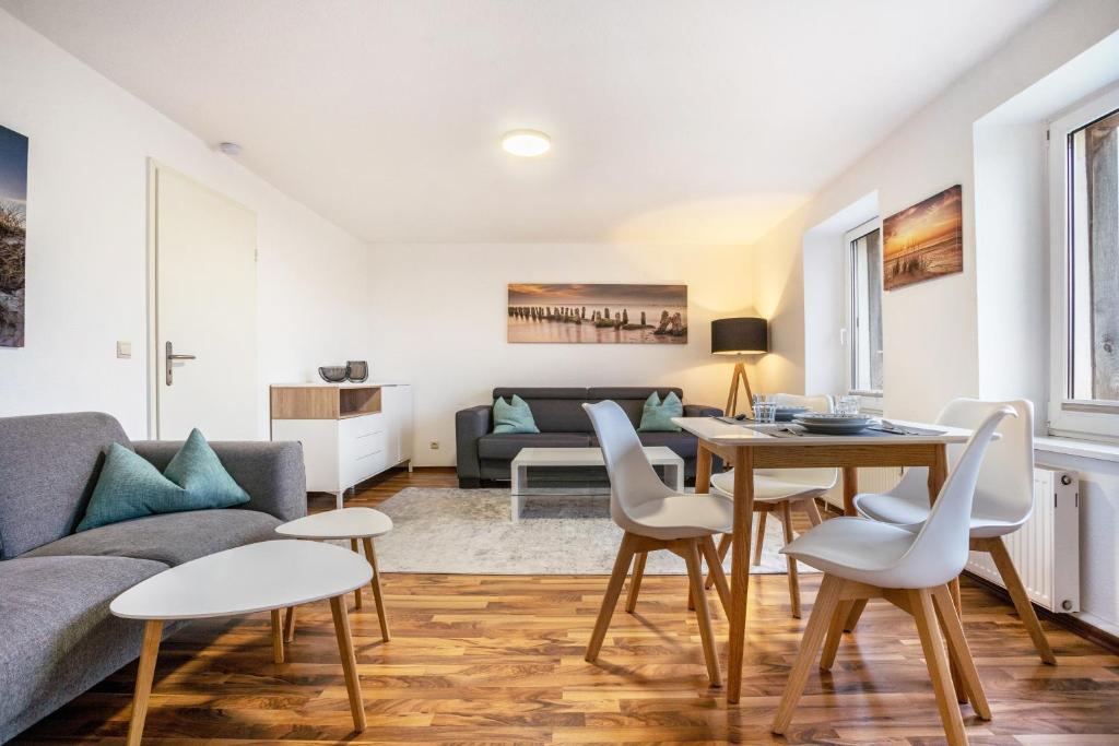 a living room with a couch and a table and chairs at Ferienapartment 2 Heimathafen in Seedorf