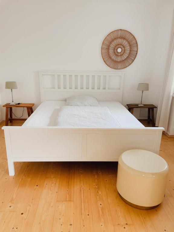 a white bed in a room with two tables at Ferien in der Flurstraße in Velbert