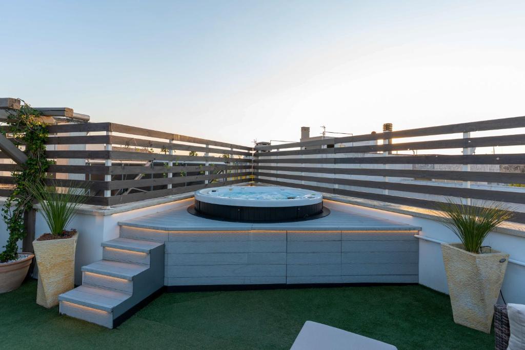 a patio with a hot tub on top of a building at Il Panoramico - Terrazza e Jacuzzi in Neviano