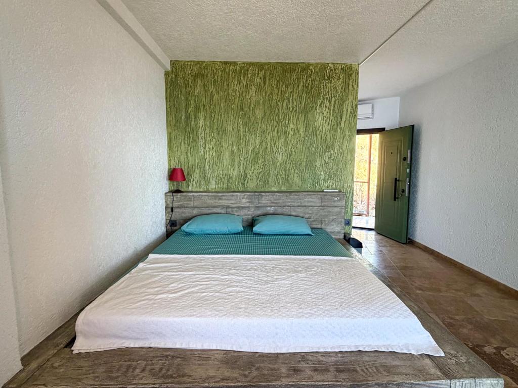a bedroom with a bed with two blue pillows at Alınca Elm Pansiyon in Fethiye