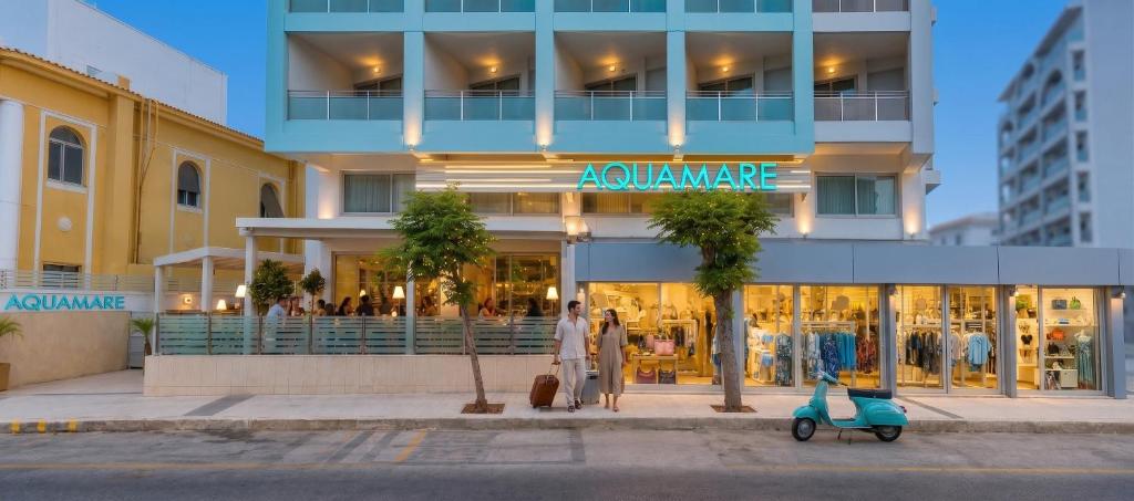 a man standing in front of a building with a scooter at AQUAMARE CITY and BEACH in Rhodes Town