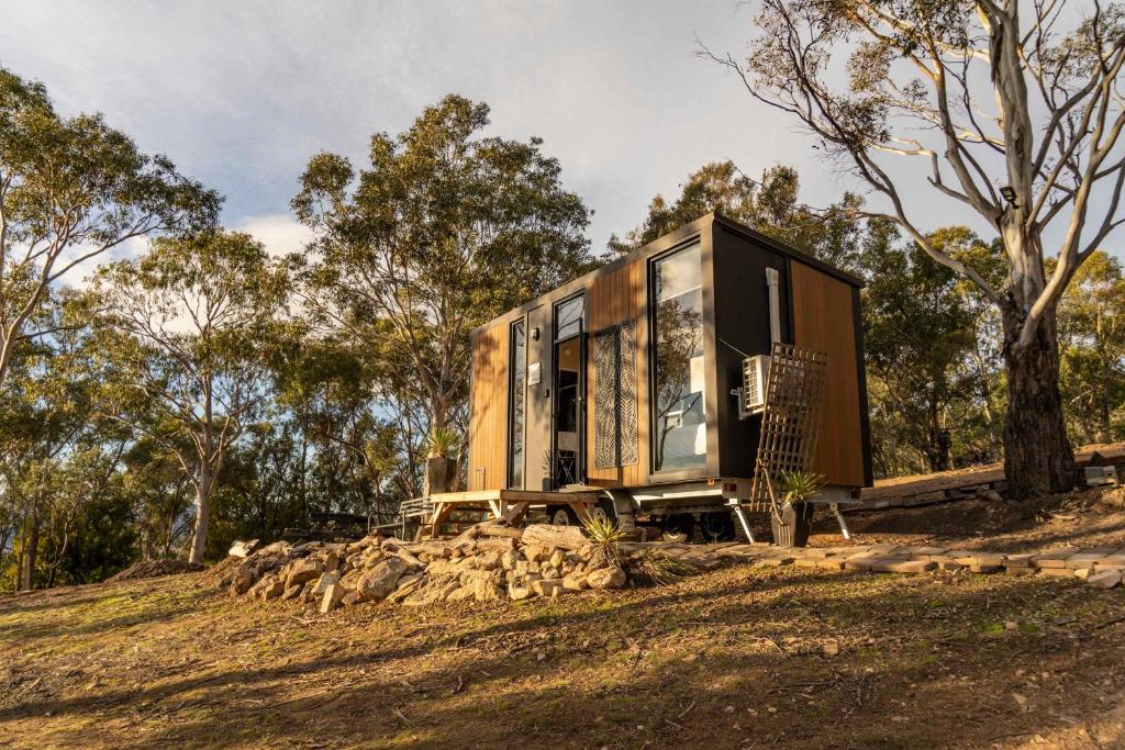 a tiny house sitting on top of a hill at Black Snake Sky Box by Tiny Away in Grantow