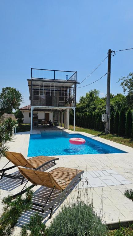 a swimming pool with two lounge chairs and a frisbee at VRHouse Vorbis River House in Ada Skeljanska