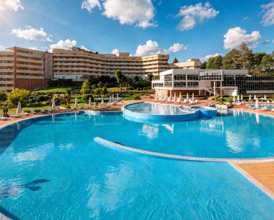 a large pool with blue water in a resort at Hissar Spa Hotel in Hisarya