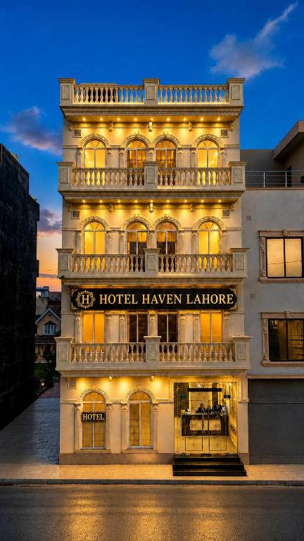 a building with a hotel harvey lanlords lit up at night at Hotel Haven Lahore in Lahore
