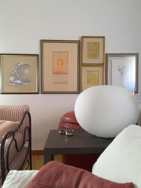 a living room with a table and pictures on the wall at B&B I Sassetti in Foligno