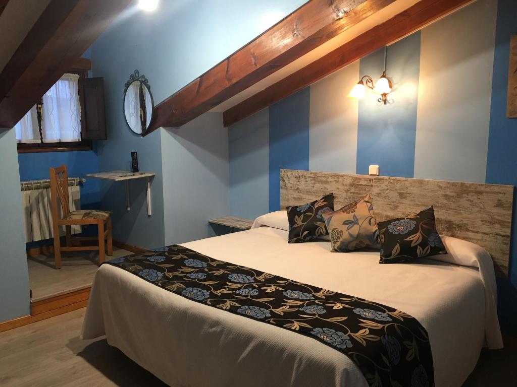 1 dormitorio con 2 camas y paredes azules en Posada rural el rincón de Cabrojo, en Cabrojo