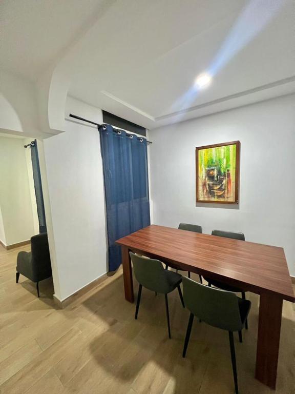 a dining room with a wooden table and chairs at Tchaopremium in Lomé