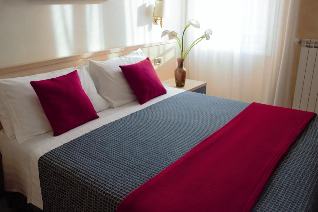 ein Schlafzimmer mit einem großen Bett mit lila und weißen Kissen in der Unterkunft Città Eterna Guest House in Rom